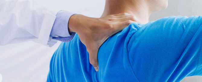 Orthopaedic Team Physical Therapist applying manual therapy to a patient's shoulder.