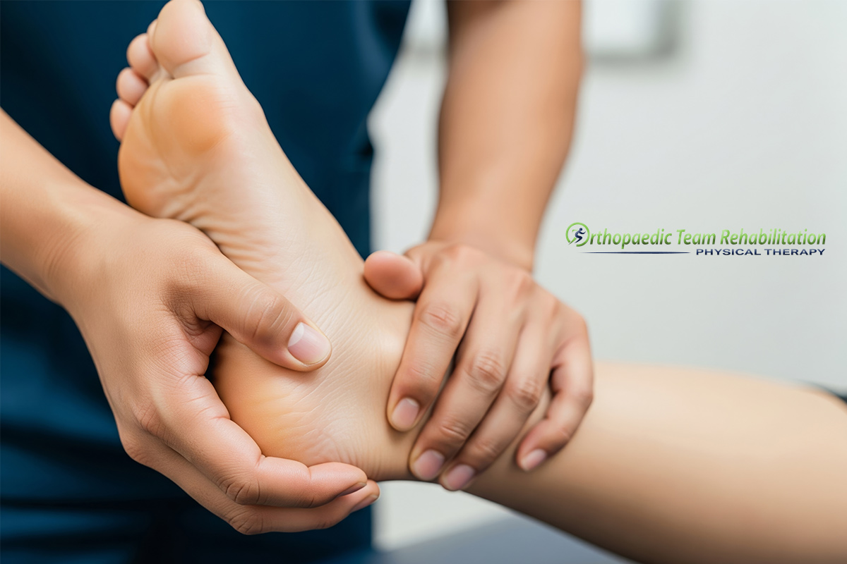 Physical therapist performing hands-on treatment for plantar fasciitis on a patient's foot.